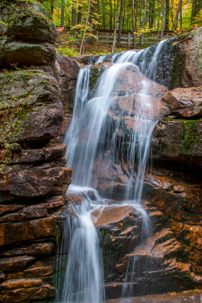 istock Stream and waterfall flowing through sculptured rocks in the woods 1281153640