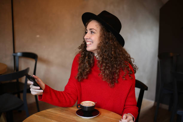 istock Young woman enjoy coffee while using the phone 1281153695
