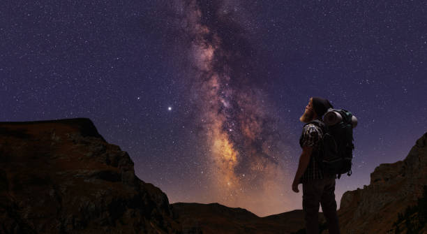 istock Hiker looking at a mountain range with stars and the milky way on night sky 1281154791