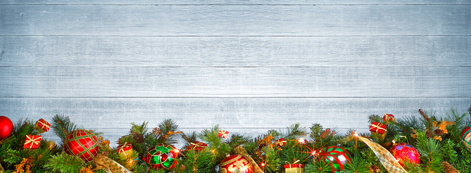 A Christmas garland on whitewashed wooden planks.