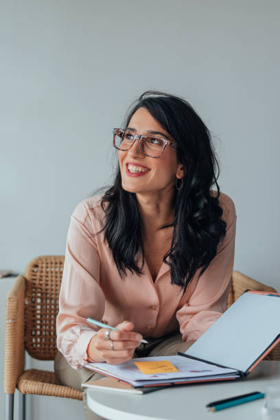 istock Beautiful Smiling Businesswoman Signing Documents at Work 1281159427