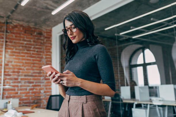 Young Businesswoman Using a Smartphone in the Office (Copy Space)