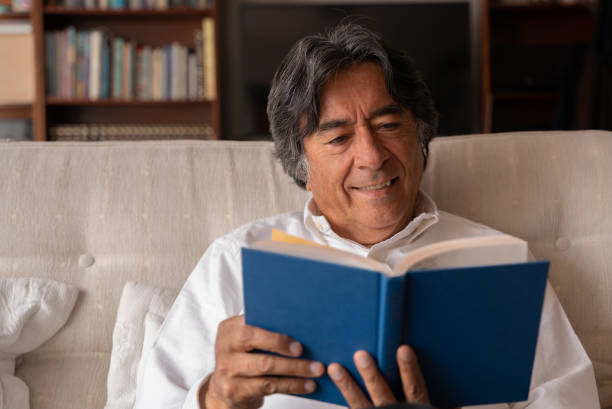 istock Man reading a book at home during the quarantine wearing glasses 1281159818