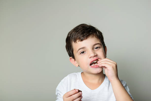istock 6 year old child eating a mini Brazilian honey cake. 1281168894