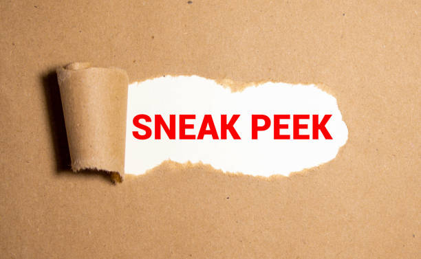 The phrase Sneak Peek appearing behind torn brown paper. stock photo