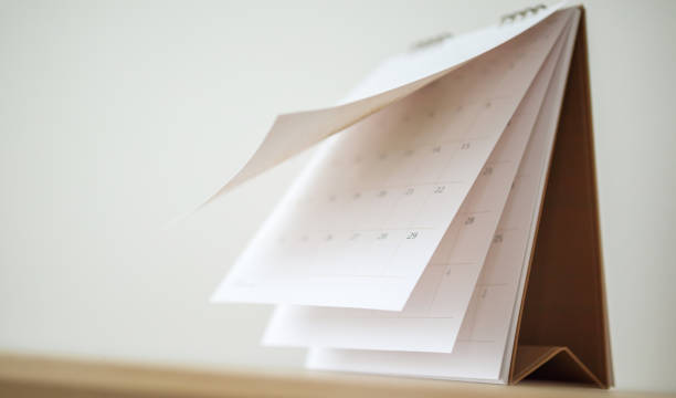 istock Blur Calendar page flipping sheet on wood table background business schedule planning appointment meeting concept 1281172829