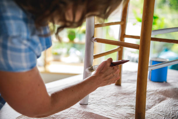 istock Woman using free time to refurbish old chair 1281173029