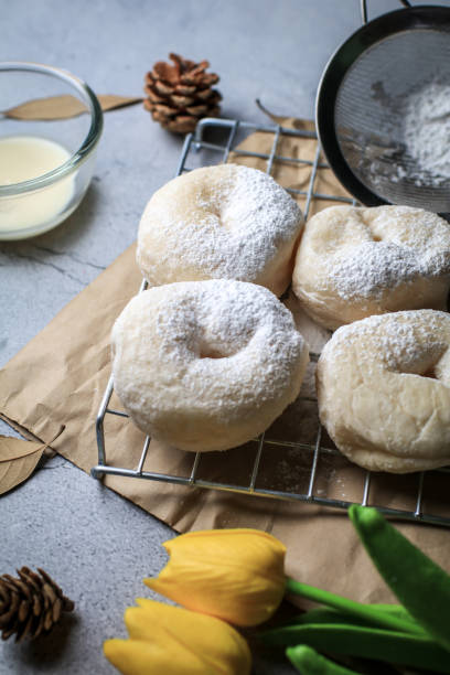 istock Delicious freshly baked doughnuts with powdered sugar on dark background. Breakfast concept, Selective focus. 1281176327