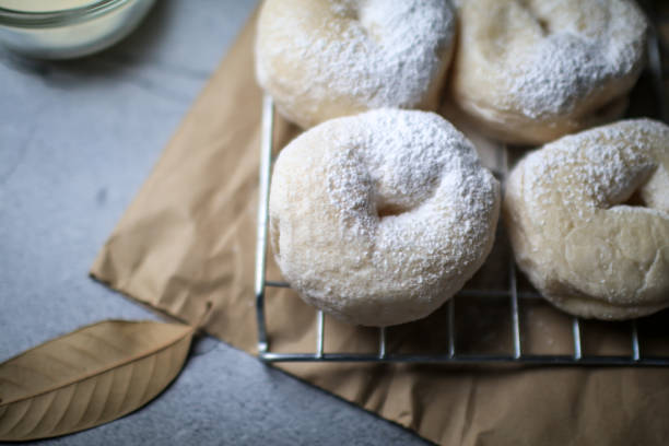 istock Delicious freshly baked doughnuts with powdered sugar on dark background. Breakfast concept, Selective focus. 1281176337