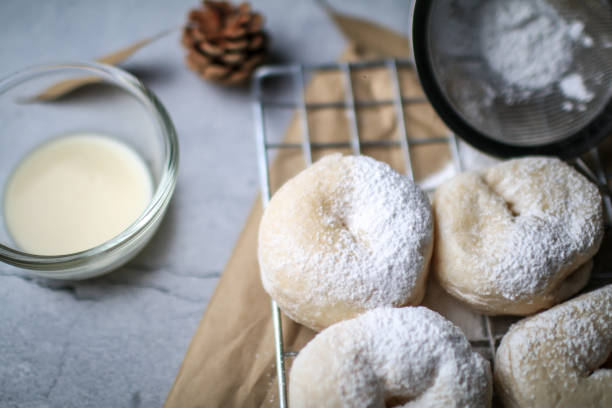 istock Delicious freshly baked doughnuts with powdered sugar on dark background. Breakfast concept, Selective focus. 1281176365