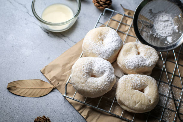 istock Delicious freshly baked doughnuts with powdered sugar on dark background. Breakfast concept, Selective focus. 1281176379
