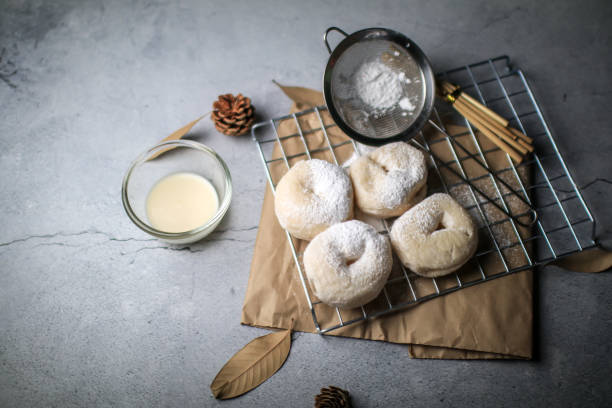 istock Delicious freshly baked doughnuts with powdered sugar on dark background. Breakfast concept, Selective focus. 1281176393