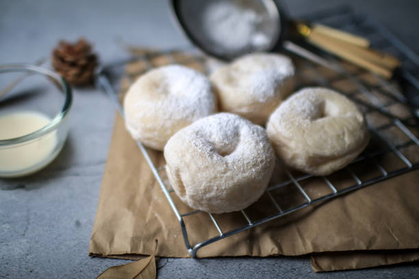 istock Delicious freshly baked doughnuts with powdered sugar on dark background. Breakfast concept, Selective focus. 1281176525