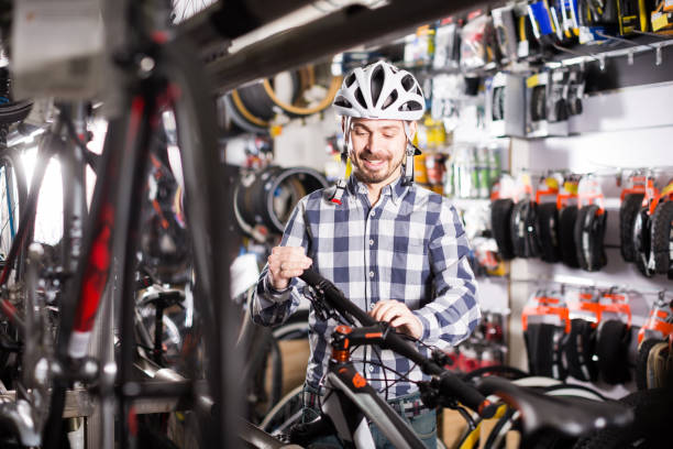 istock Man in helmet examining a selected bike 1281177531