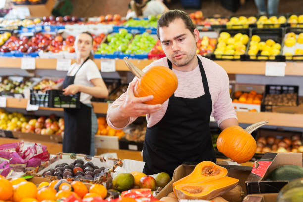 istock Seller with pumpkin in supermarket 1281177644