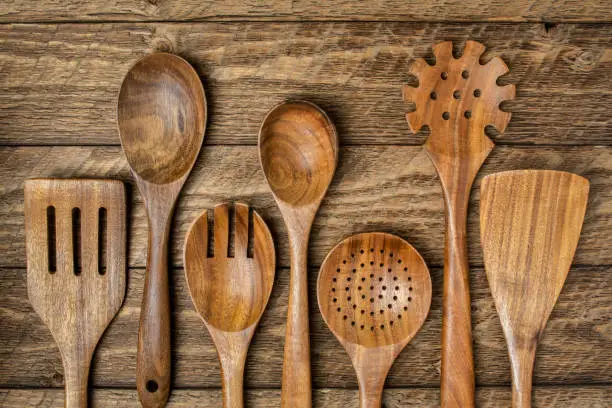 wooden kitchen cooking utensils set on a rustic weathered barn wood background