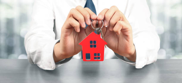 istock Real estate agent handing over house keys 1281184307