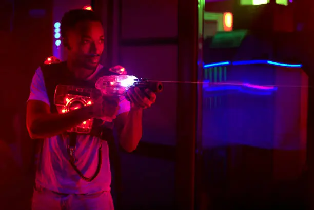 laser tag player holding gun in amusement center playing game