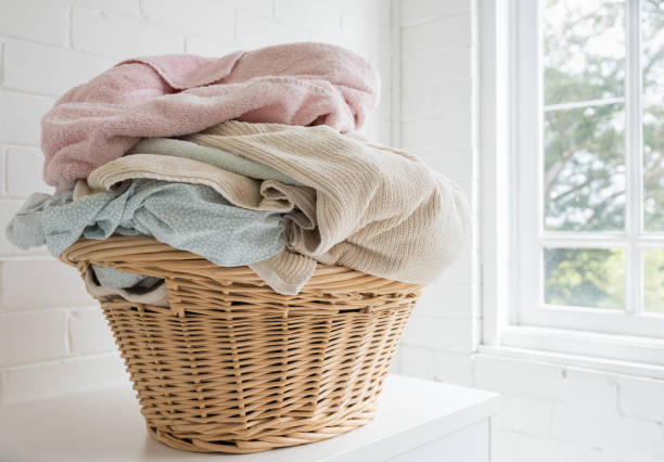 istock Pink towel and blue sheets in basket next to window 1281186711