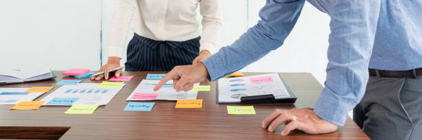 istock Businessman stick colorful notes to brainstorming on the table working on new project to share idea to thinking how to planning new case. 1281187395