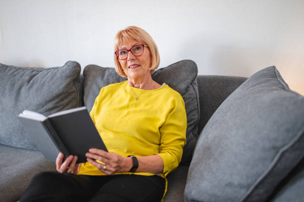 istock Senior Woman Reading A Book On The Sofa 1281189059