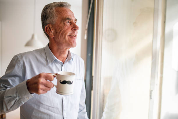 istock Senior Man Drinking Coffee And Looking Out The Window 1281189064