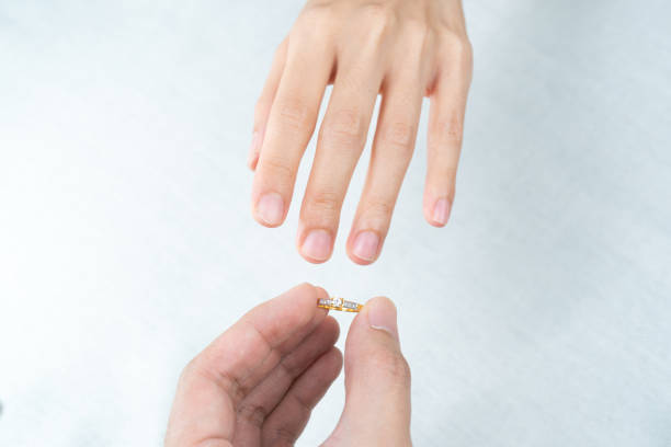 istock Man putting diamond ring on woman hand over white background. 1281191533