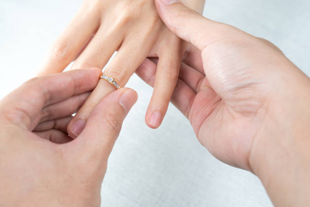 istock Man putting diamond ring on woman hand over white background. 1281191564