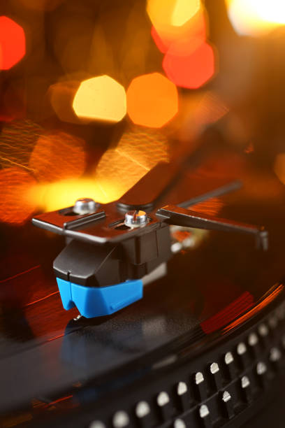 Vinyl player tonearm with LP record and blured or defocused lights. Party disco concept