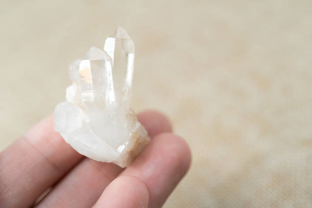 istock Hand holding clear quartz over brown background. 1281192293