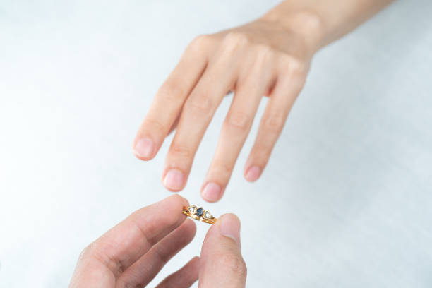istock Man putting diamond ring on woman hand over white background. 1281192538