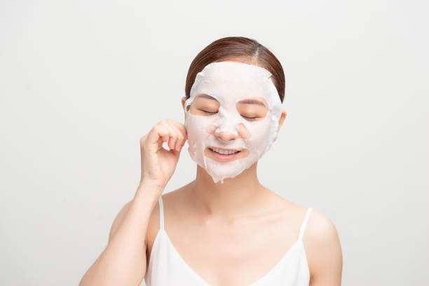 Facial mask looking at camera over white background. Cosmetic procedure. Beauty spa and cosmetology. Woman beauty face