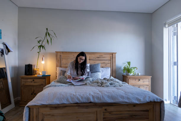 istock Young woman sits in her bed and studies 1281193724