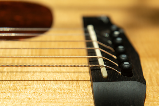 Close-up shot of bronze guitar strings on acoustic guitar
