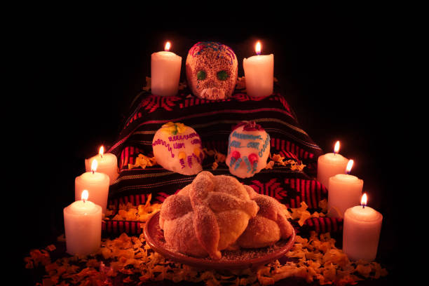 Mexican day of the dead altar with bread and sugar skulls on dark background Traditional mexican day of the dead altar with bread and sugar skulls on dark background altar photos stock pictures, royalty-free photos & images