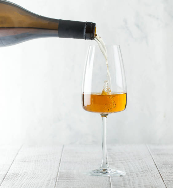 istock Orange wine is poured into a glass from a bottle. Copy space. 1281198563