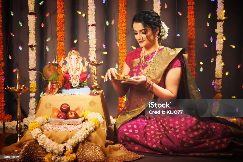 Young Indian woman celebrating Ganesha Festival Young Indian woman celebrating Ganesha Fesitval in traditional way Ganesh Chaturthi Stock Photo