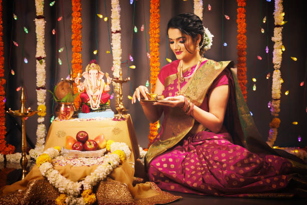 Young Indian woman celebrating Ganesha Festival Young Indian woman celebrating Ganesha Fesitval in traditional way ganesh chaturthi photos stock pictures, royalty-free photos & images
