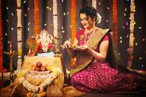 Young Indian woman celebrating Ganesha Fesitval in traditional way