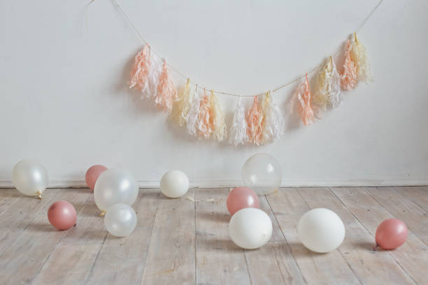 decoración de cumpleaños. guirnalda rosa en una pared blanca, bolas en el suelo - fashionable party design home decorating fotografías e imágenes de stock