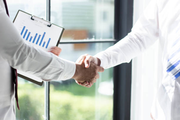 istock Two business people shake hands after a meeting 1281203596