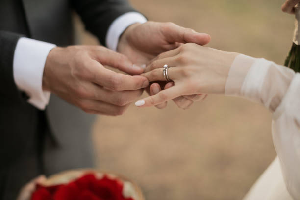 istock Close up groom putting the wedding ring on bride. Tropical wedding. 1281205894