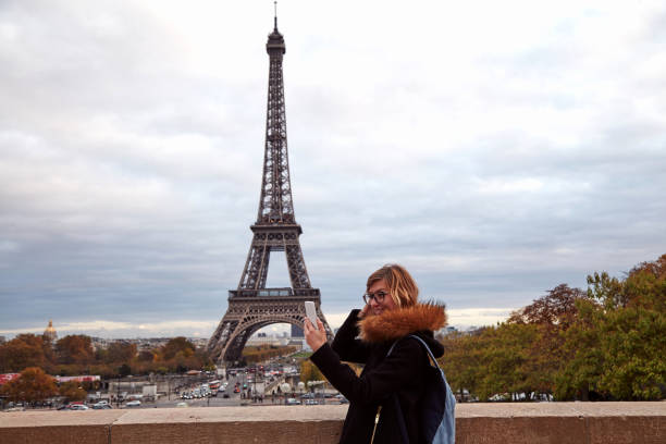 istock Girl using cellphone with Paris city background and Eiffel tower. 1281206633