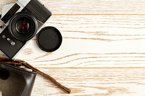 Retro film camera on the wooden surface. Vintage flat lay template with copy space for text