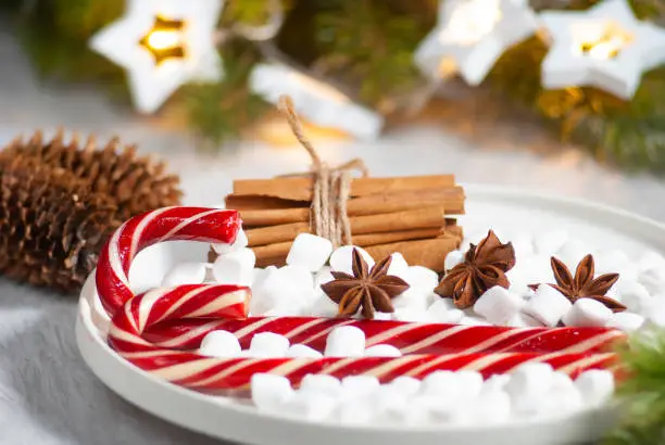 Christmas tasty set of candy cane, marshmallows and cinnamon stick with anis stars celebration table decorations. New year winter holiday.