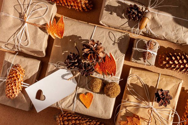 Zero waste Christmas knolling flat lay with hard shadows. Hand crafted eco gift, natural New Year jute decorations top view. Kraft paper wrapping without plastic concept. Orange zest trees, hearts and cones cero desperdicio navidad que knolling plana yacía con sombras duras. regalo ecológico hecho a mano, decoraciones naturales de yute de año nuevo vista superior. envoltura de papel kraft sin concepto de plástico. naranja árbol ralladura, corazones, cono