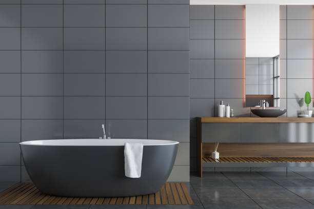 istock Gray tile bathroom with tub and sink 1281211229