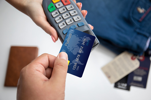 woman and man hands holding plastic card and pay pass online terminal in the store