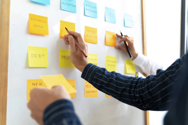 istock Team working in office putting sticky note on white board analyzing strategy of business. 1281212930