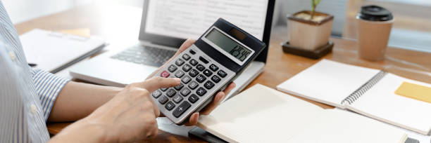 istock Business woman using calculator analyzing data report at home. 1281213064